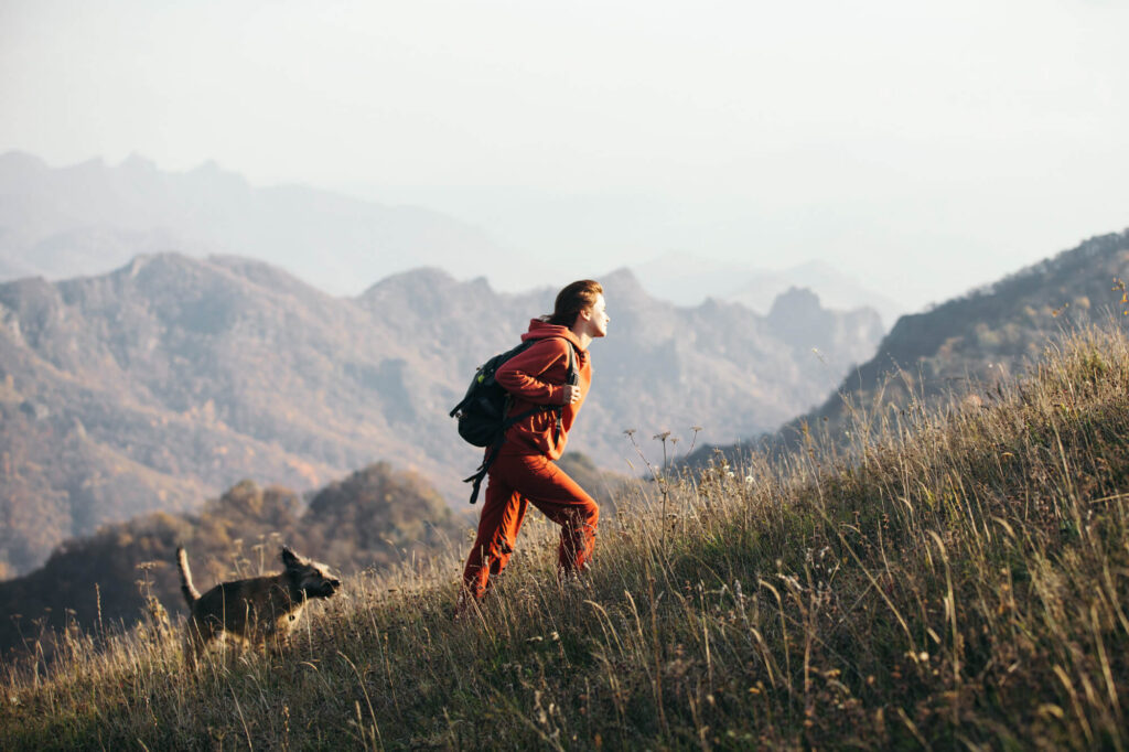 Woman hiking with her dog in the mountains